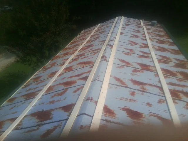 Rusted metal roof panels with new wood purlins before replacement — Storm Damage Roof Repair in Farnham by Roofing Brothers