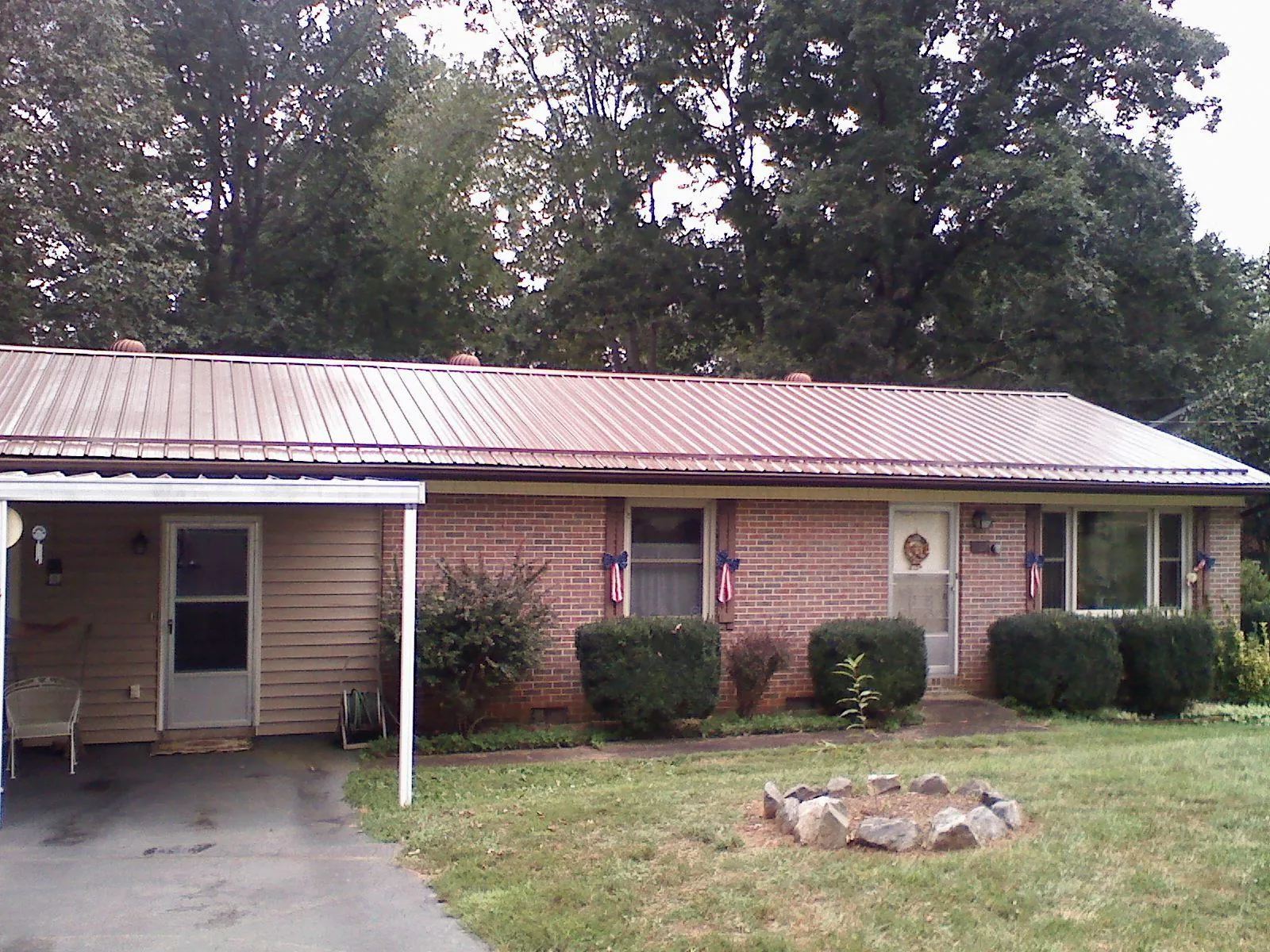 Bronze metal roof and carport on a brick ranch home — Roof Repair work by our crew in Farnham